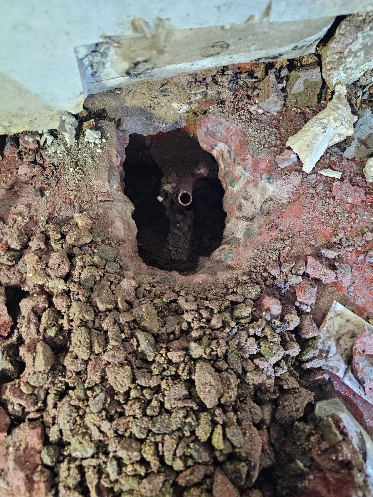 Floor opened to reach the buried pipe