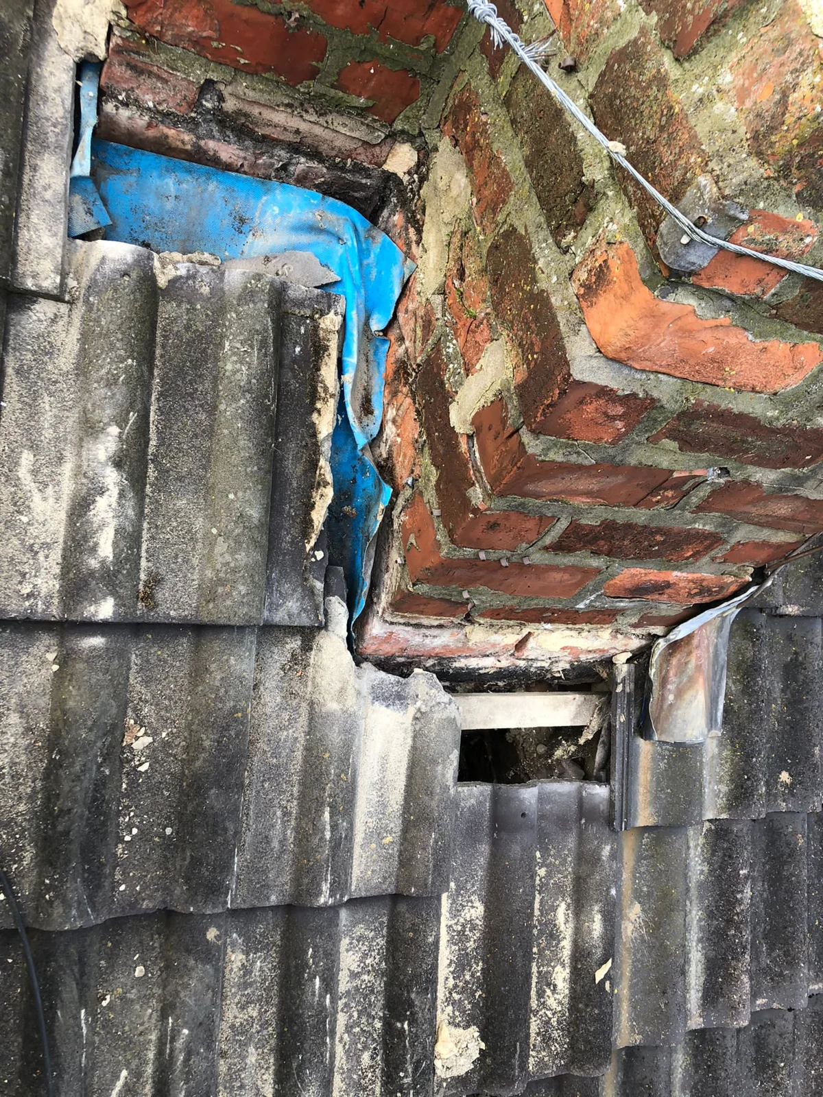 Opened roof junction beside the brick chimney