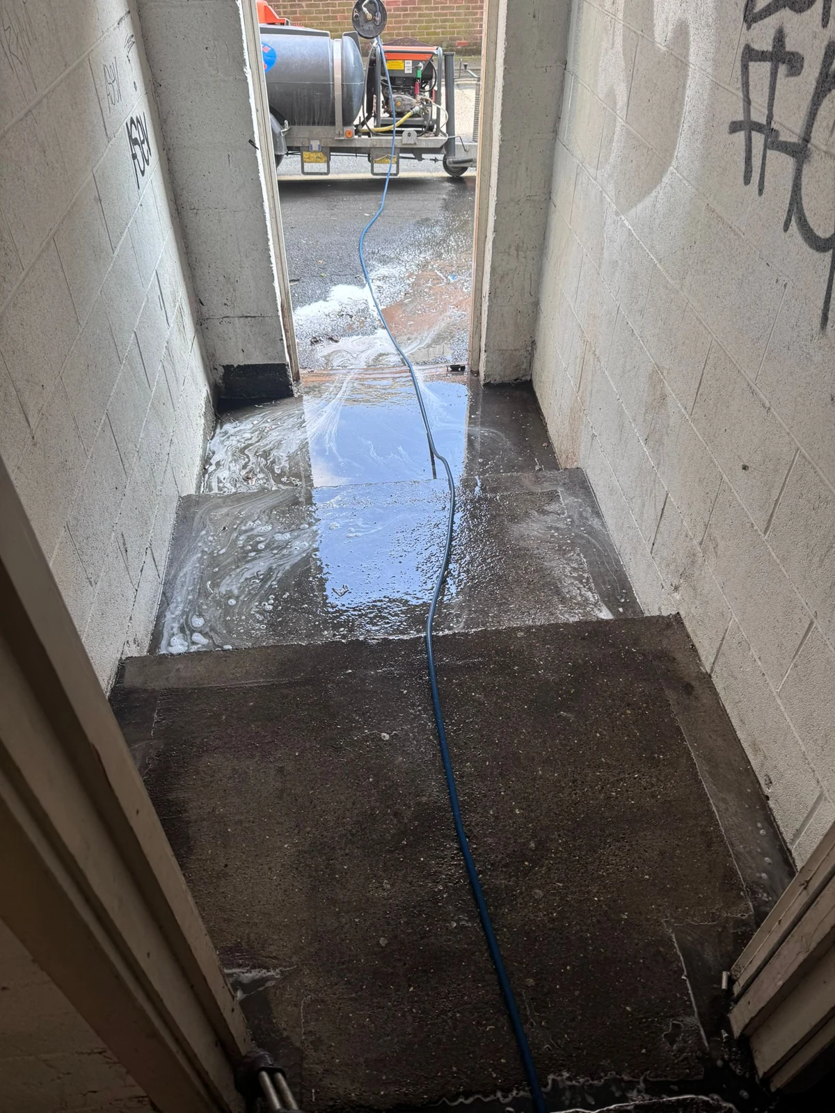 Wet concrete stairs and a cleaning hose at the Newcastle car park