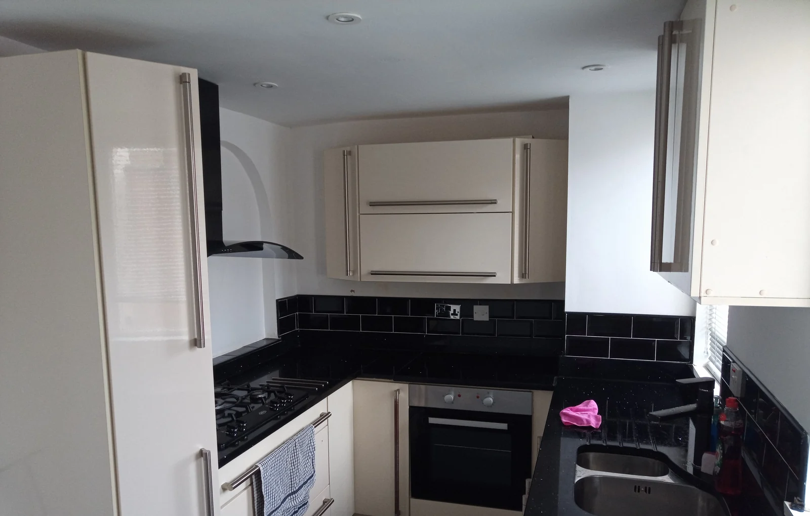 Cream kitchen cabinets and black tiled splashback at the Seaham property