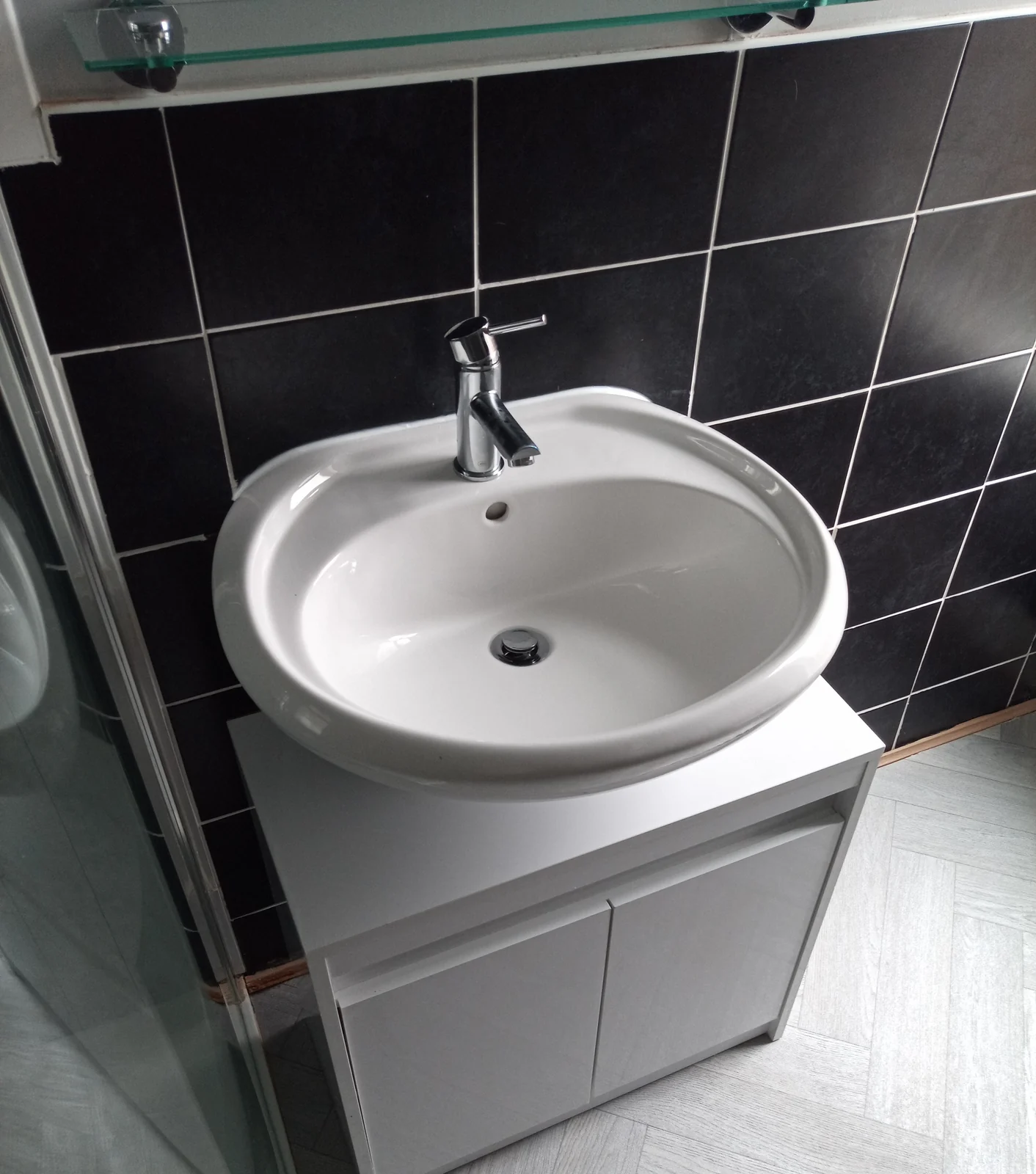 Replacement white basin and vanity unit above grey bathroom flooring