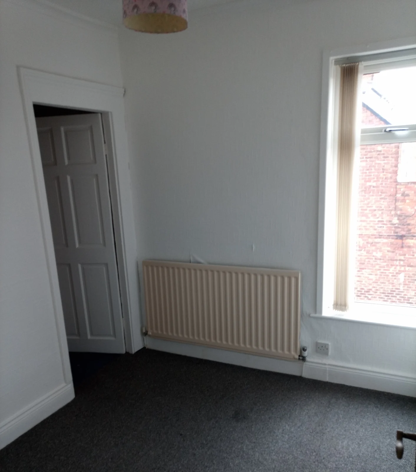 Freshly decorated bedroom with grey carpet and a white radiator