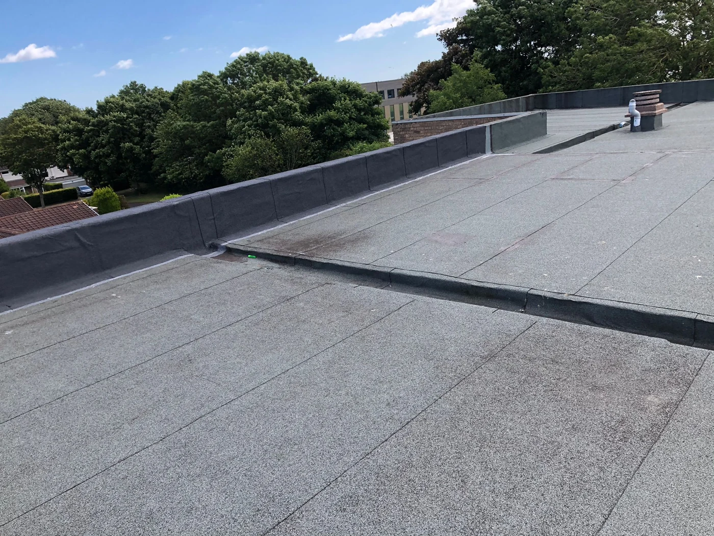 Renewed felt flashings along a flat-roof parapet in Whitley Bay