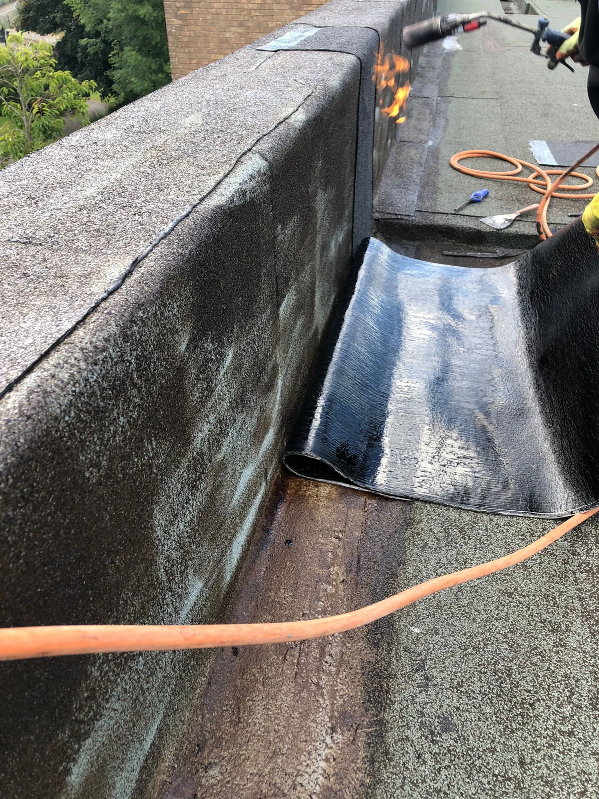 Roofing membrane being fitted at the parapet