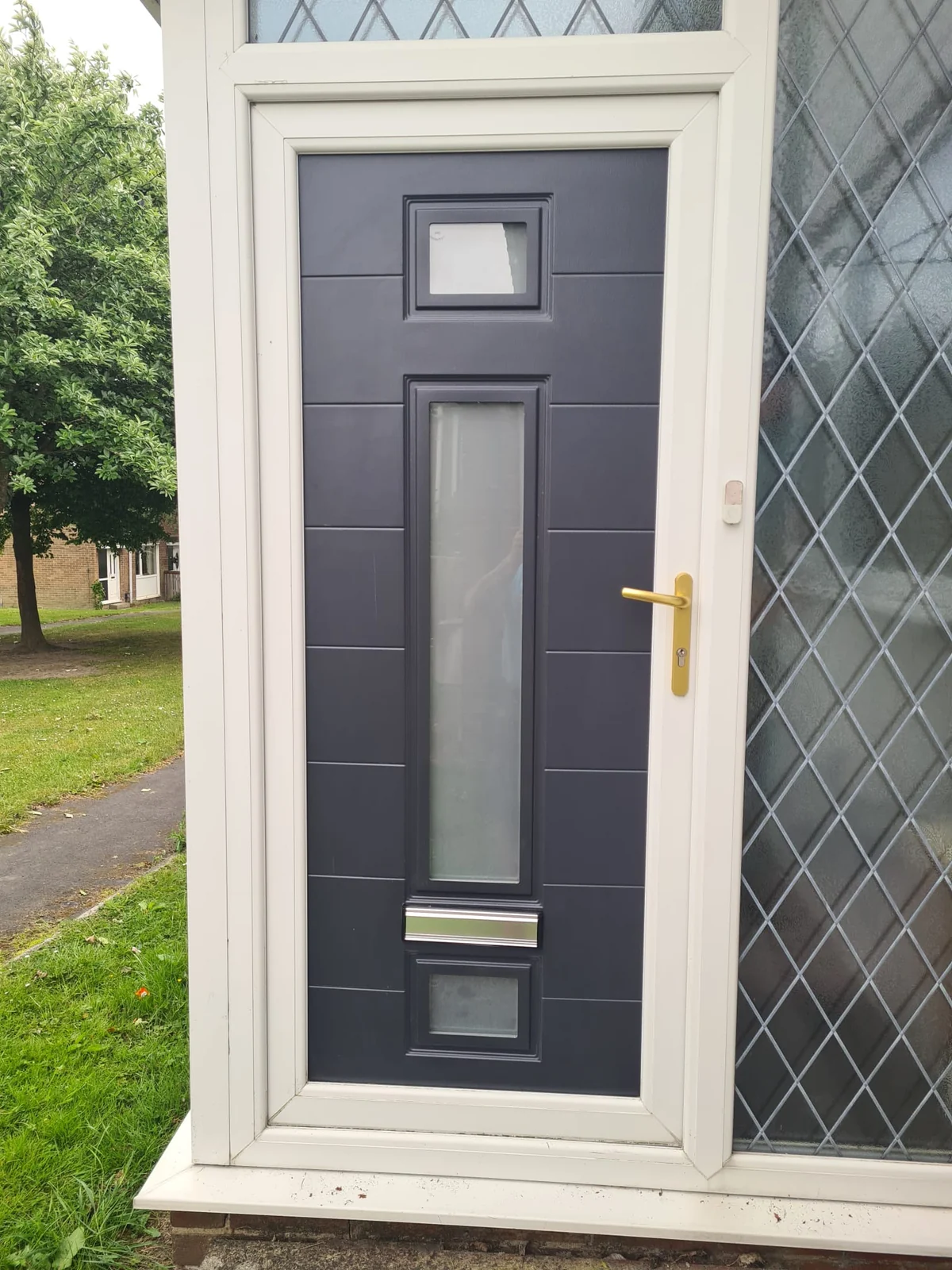 Reused uPVC door set with white frame and glazed side panel in Consett