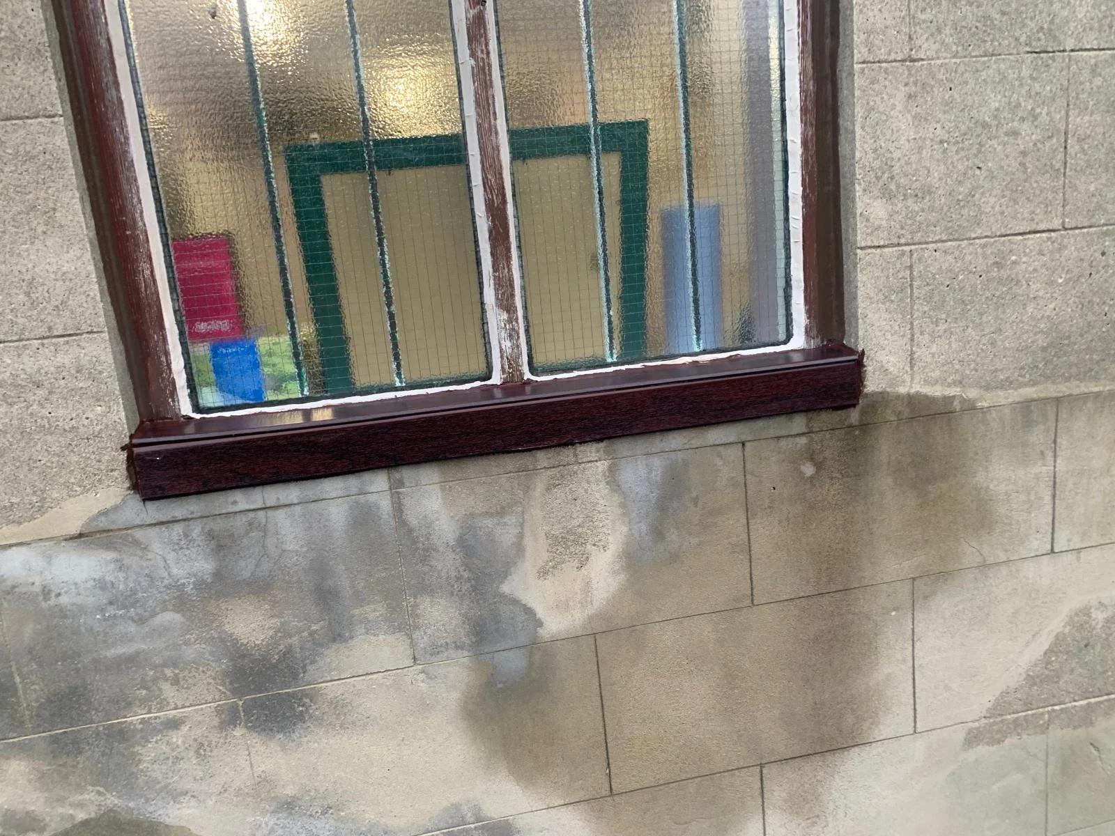 Restored dark timber window sill and frame against a stone wall